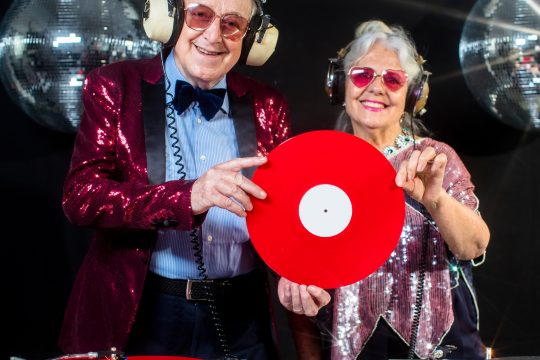 an amazing grandma and grandpa, older couple djing and partying in a disco setting