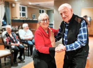 Senior couple dancing and smiling.